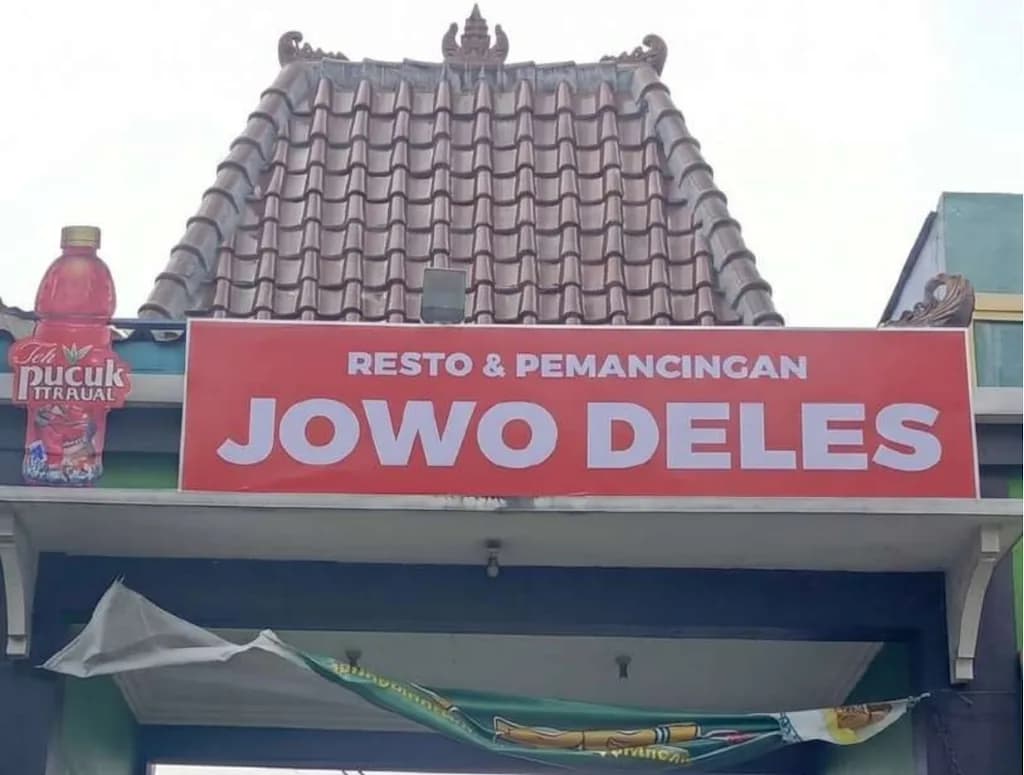 Papan nama resto Jowo Deles dengan cut-out botol Teh Pucuk